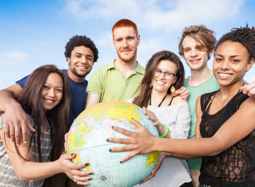 6 Personen vor einem blauen Himmel, die gemeinsam einen Globus festhalten